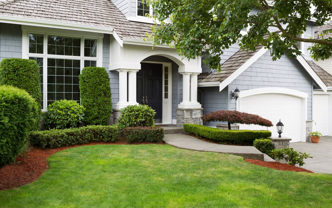 Newly painted and stained exterior of modern home during summert Residential Roofing | Stanley & Orke